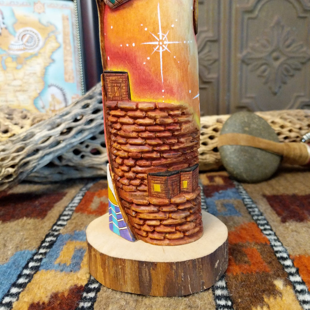 Wood carved into a sun kachina painted with vibrant colors and intricately carved wood details.
