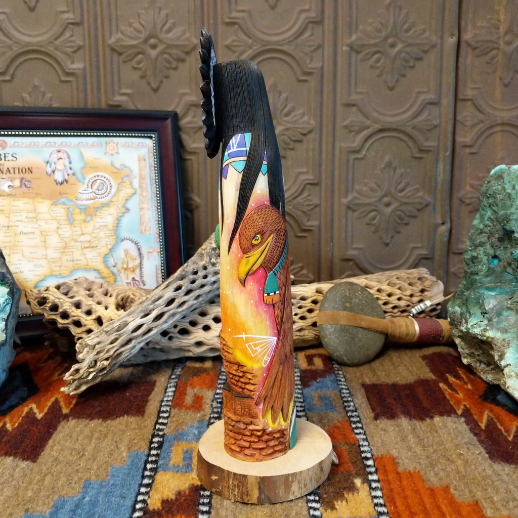 Wood carved into a sun kachina painted with vibrant colors and intricately carved wood details.