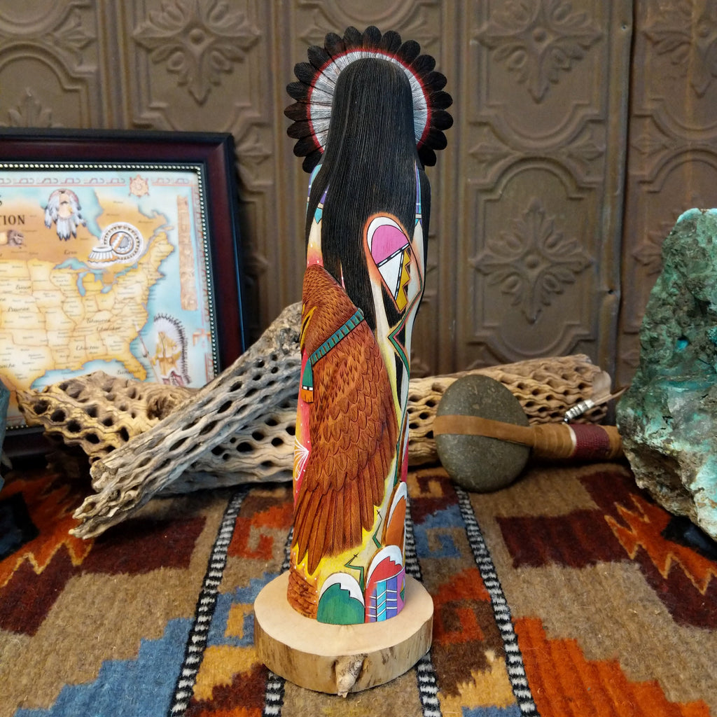 Wood carved into a sun kachina painted with vibrant colors and intricately carved wood details.