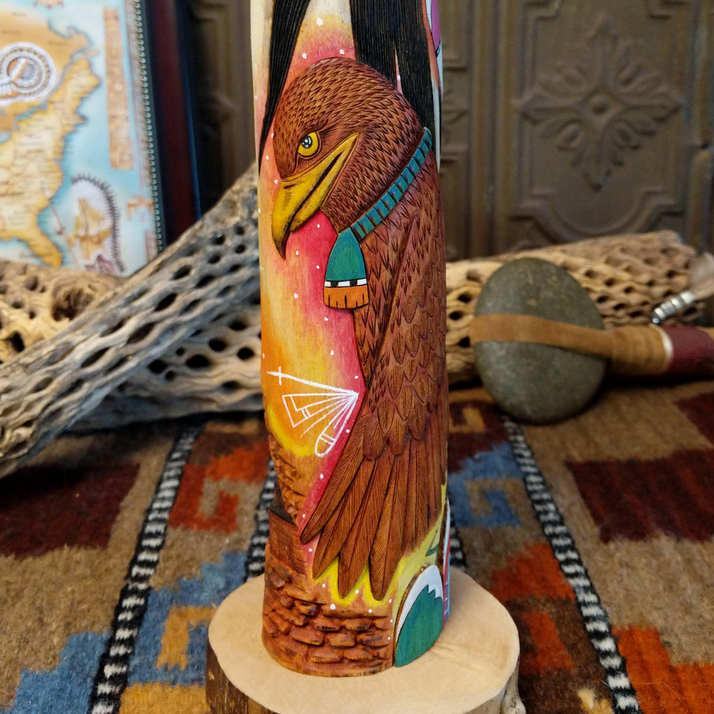 Wood carved into a sun kachina painted with vibrant colors and intricately carved wood details.