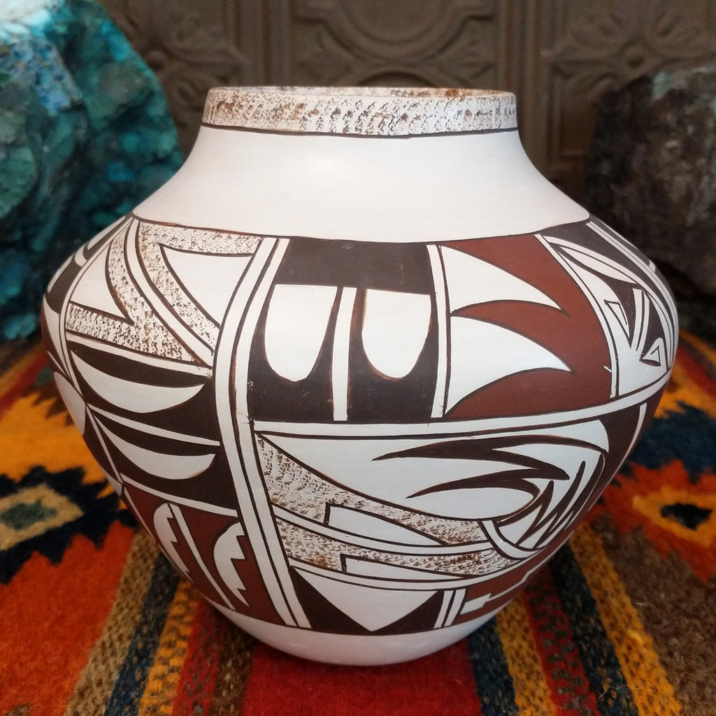 White clay pot with various geometric designs and sponge detailing.
