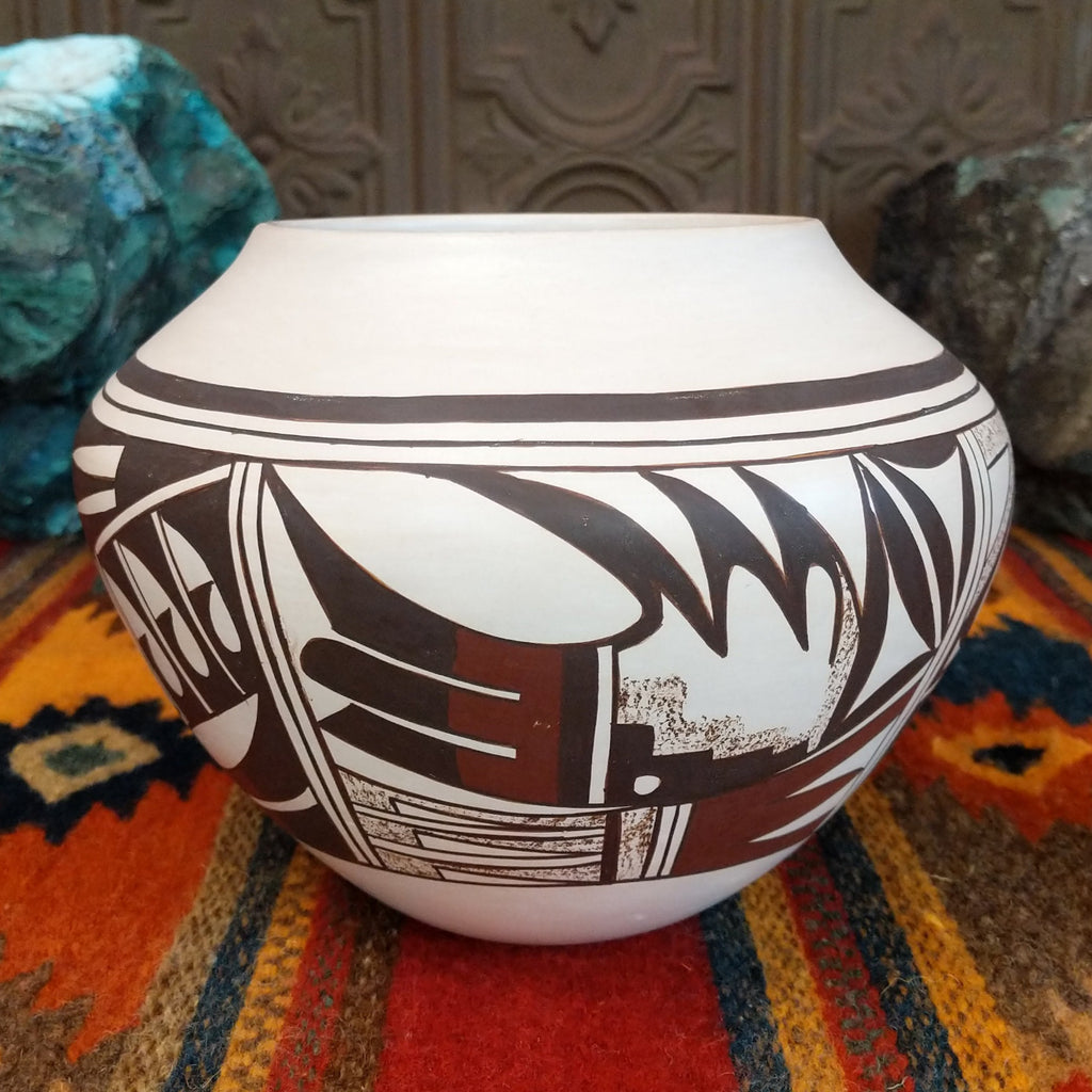 White clay with various geometric designs in brown and red with sponge techniques.