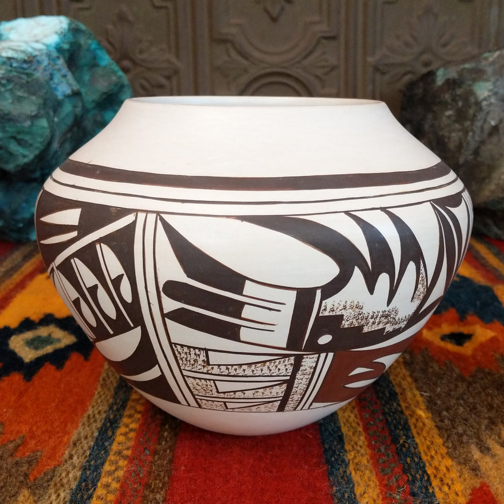 White clay with various geometric designs in brown and red with sponge techniques.