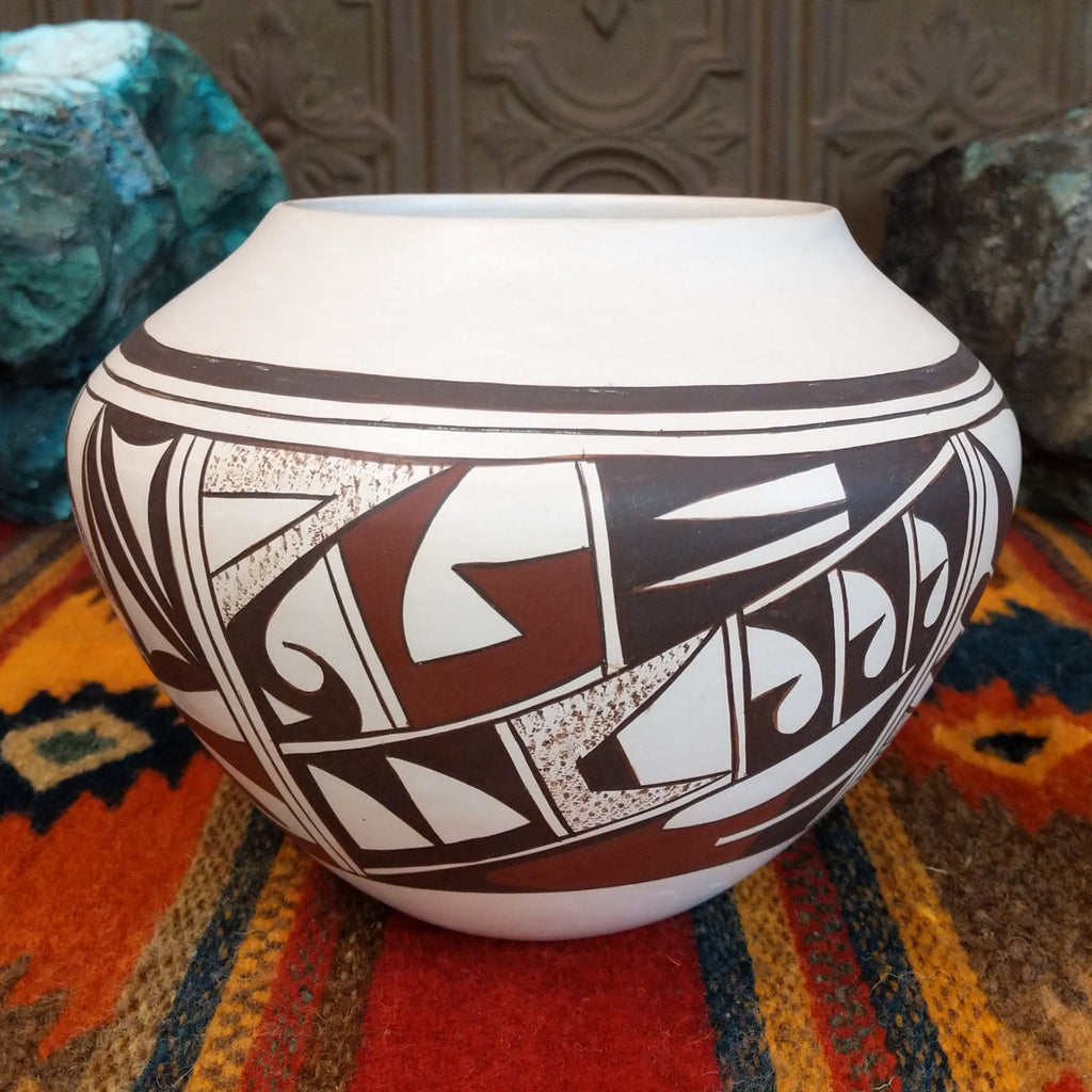 White clay with various geometric designs in brown and red with sponge techniques.