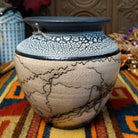This distinctive Horsehair Pottery by Roger Calhoun features a rounded ceramic vessel with natural earth tones, delicate black horsehair patterns, a decorative crackled upper section, and a wide black rim.