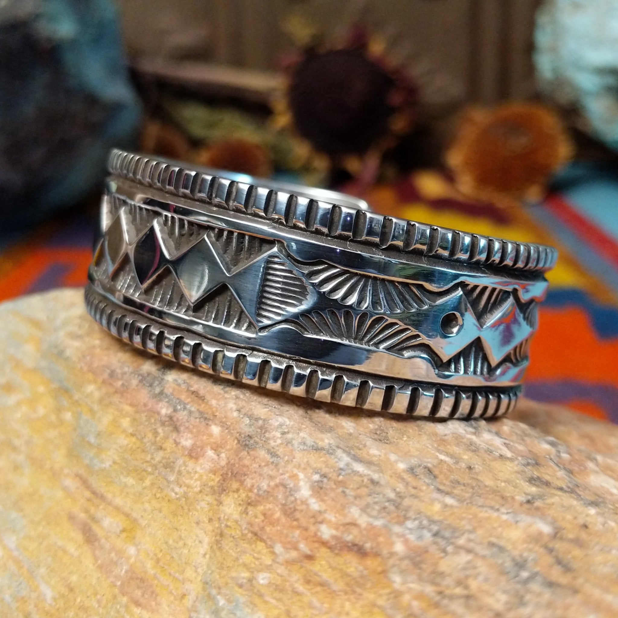 Wide silver cuff by Elvira Bill with repeating zigzag design, stamped accents, and detailed borders.