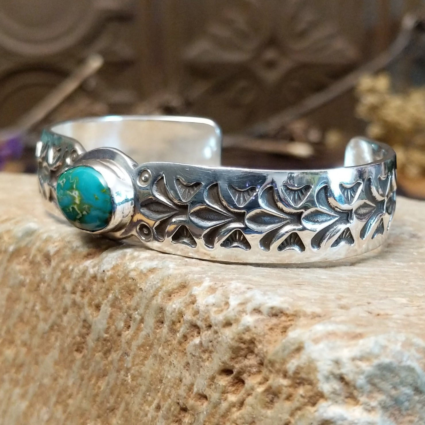 Sterling silver cuff with Sonoran gold turquoise set in an oval bezel and floral stamping along the surface of the band.