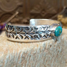 Sterling silver cuff with Sonoran gold turquoise set in an oval bezel and floral stamping along the surface of the band.