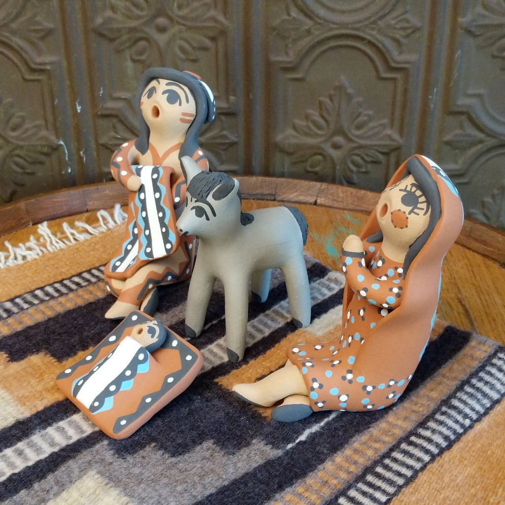 Clay made into a mother, father, baby, and donkey and are painted in various colorful designs.