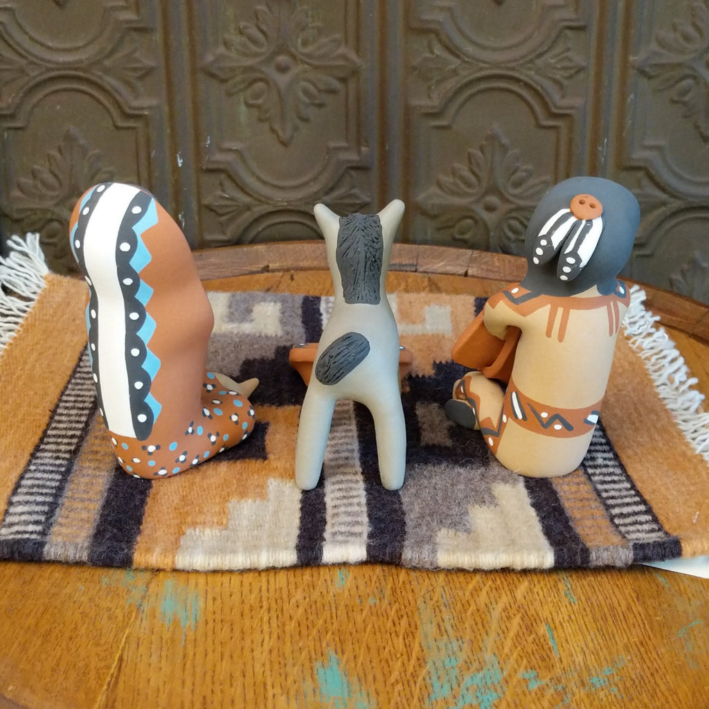 Clay made into a mother, father, baby, and donkey and are painted in various colorful designs.