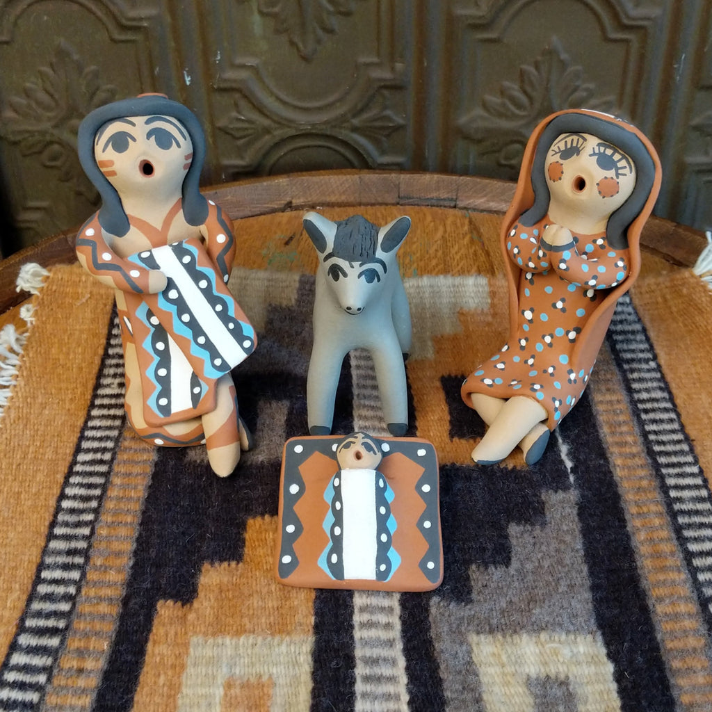 Clay made into a mother, father, baby, and donkey and are painted in various colorful designs.