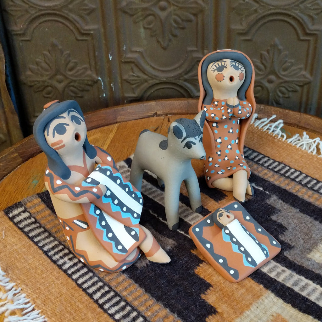 Clay made into a mother, father, baby, and donkey and are painted in various colorful designs.