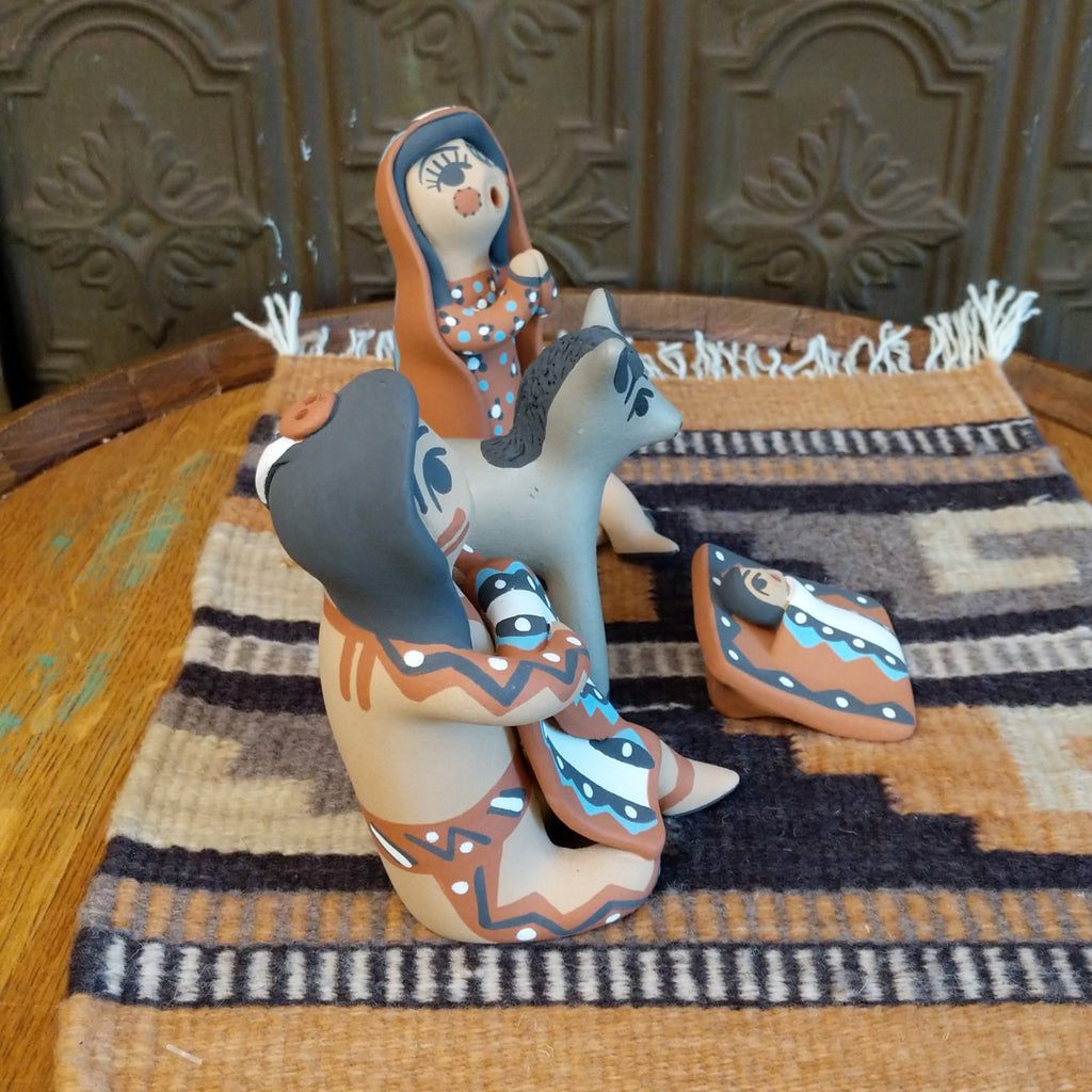 Clay made into a mother, father, baby, and donkey and are painted in various colorful designs.