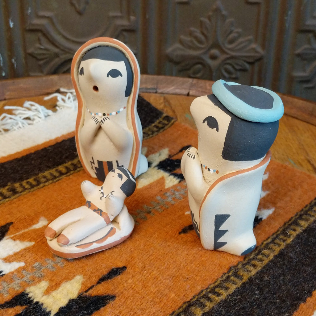 Clay sculpted into a small nativity scene and painted in the colors black, white, blue, and terracotta.