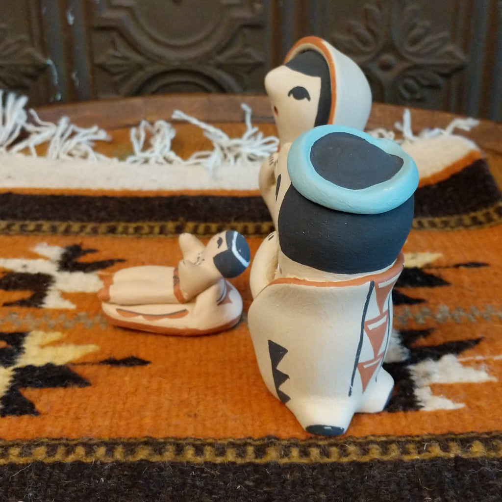 Clay sculpted into a small nativity scene and painted in the colors black, white, blue, and terracotta.