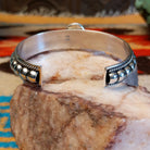 Sterling silver cuff bracelet with Kingman turquoise set in the round bezel and twisted rope with ornate silverwork accents.