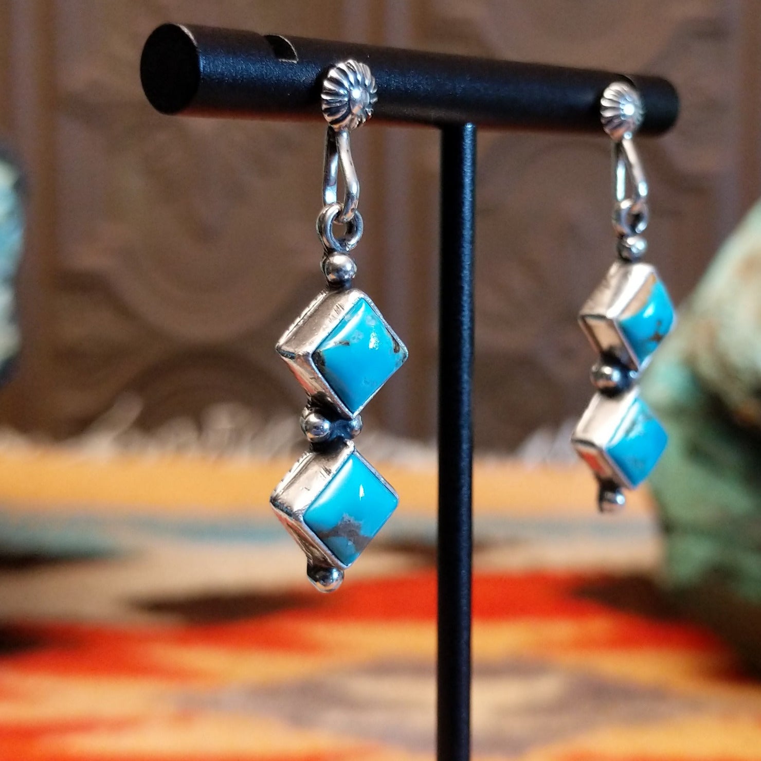 Sterling silver dangle earrings with Kingman turquoise set in the diamond-shaped bezels.
