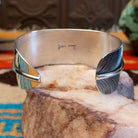 Sterling silver cuff bracelet with Kingman turquoise set in an oval bezel and feather band design.