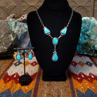 Sterling silver necklace and earring set with kingman turquoise set in the bezels, framed by twisted rope and dotted accents.