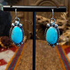 Sterling silver earrings with kingman turquoise set in the bezels, framed by twisted rope and dotted accents.