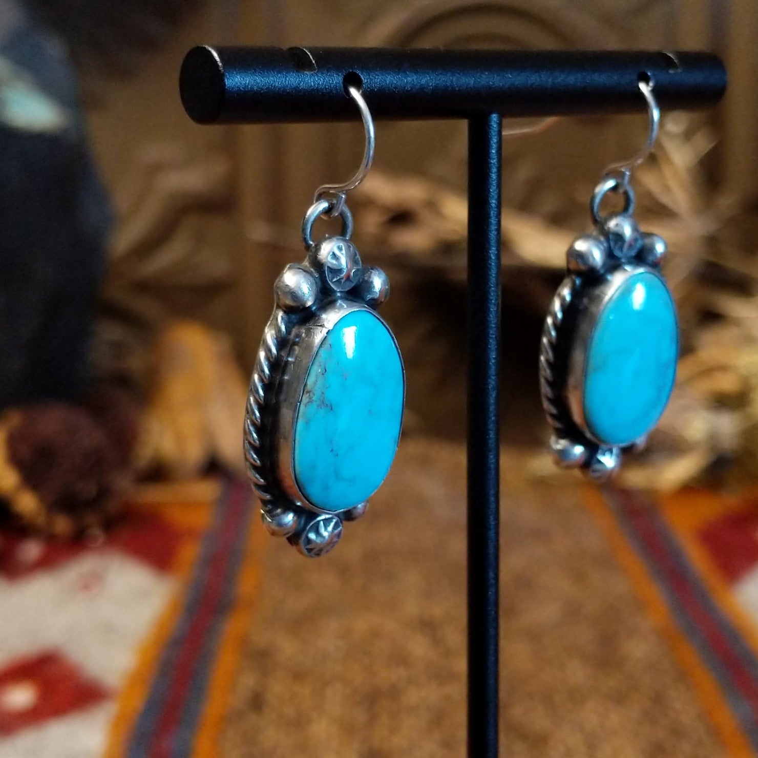 Sterling silver earrings with kingman turquoise set in the bezels, framed by twisted rope and dotted accents.