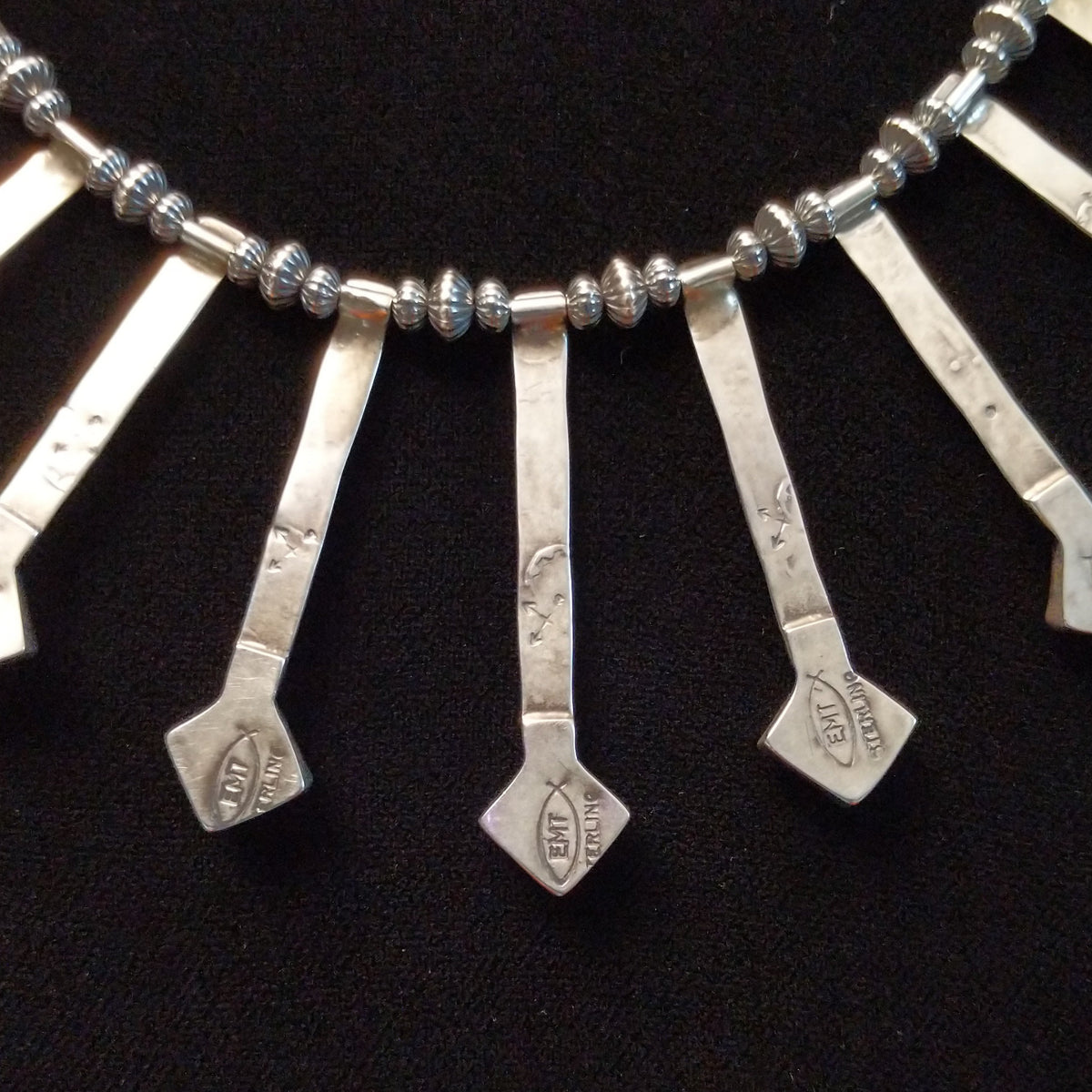 Everett & Mary Teller Kingman Turquoise necklace featuring vibrant turquoise stones, stamped Sterling Silver drops, and decorative silver beads; artisan and Sterling Silver stamp.