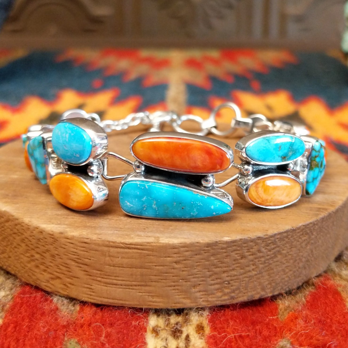Sterling silver bracelet with Kingman turquoise and orange spiny oyster shell set in geometric bezels that make up the band.