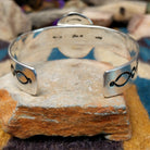Handcrafted sterling silver Navajo cuff by Charlene & Robert Little featuring an oval Kingman turquoise cabochon with a twisted rope bezel, scalloped silver border, and hand-stamped concho accents; underside view.