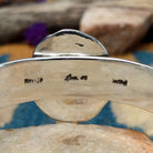 Handcrafted sterling silver Navajo cuff by Charlene & Robert Little featuring an oval Kingman turquoise cabochon with a twisted rope bezel, scalloped silver border, and hand-stamped concho accents; artisan, tribe, and Sterling Silver stamps.