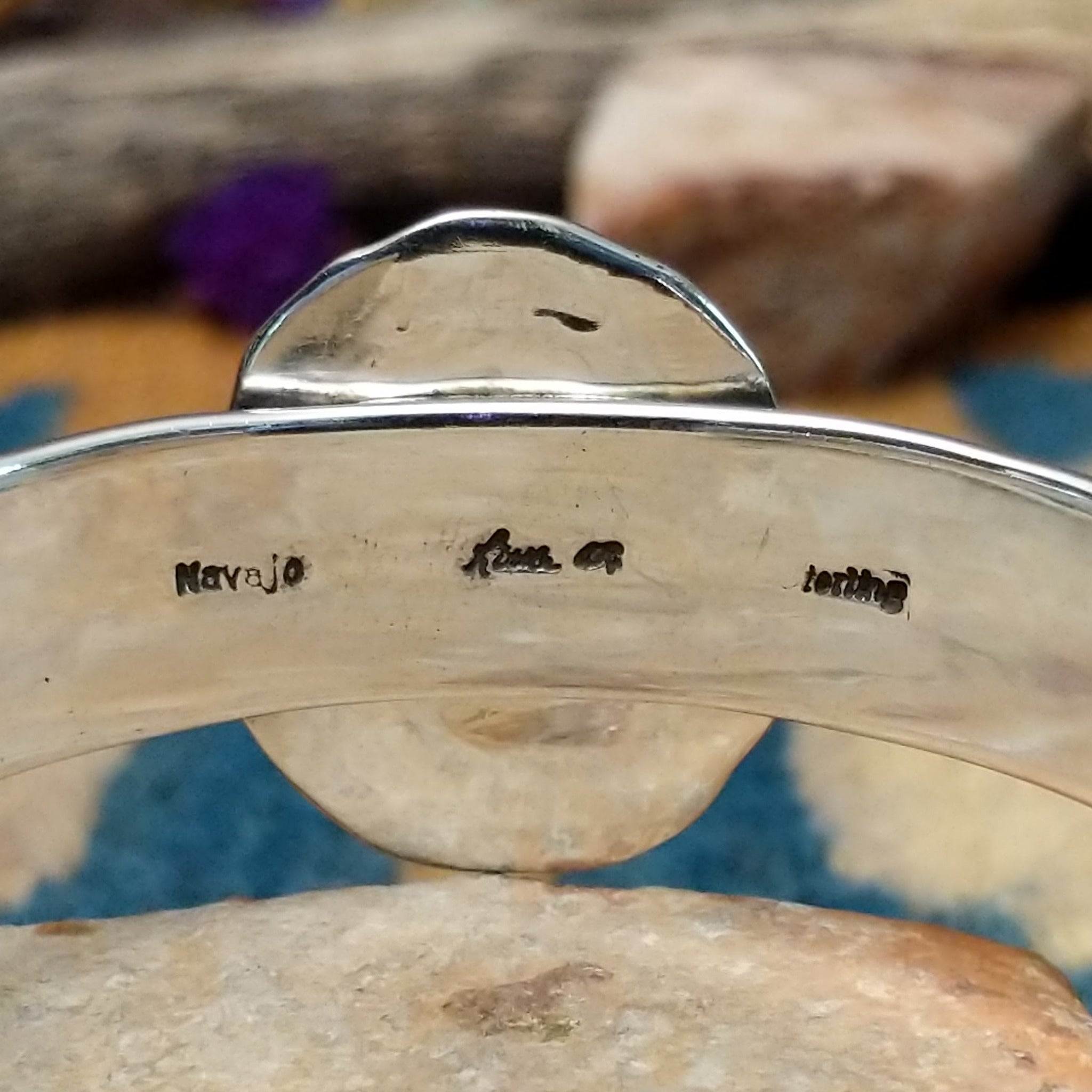 Handcrafted sterling silver Navajo cuff by Charlene & Robert Little featuring an oval Kingman turquoise cabochon with a twisted rope bezel, scalloped silver border, and hand-stamped concho accents; artisan, tribe, and Sterling Silver stamps.