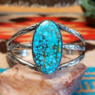 Sterling silver cuff bracelet with Kingman turquoise set in a large, oval bezel, featuring the tri-band with stamped designs.