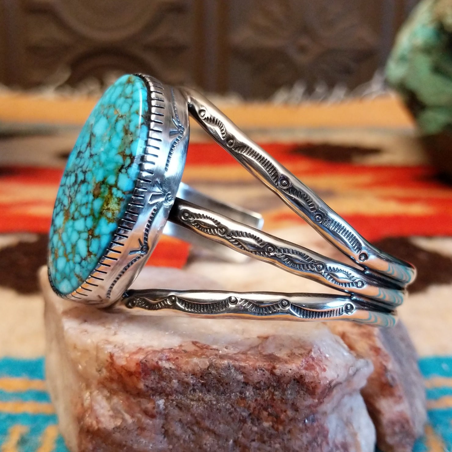 Sterling silver cuff bracelet with Kingman turquoise set in a large, oval bezel, featuring the tri-band with stamped designs.