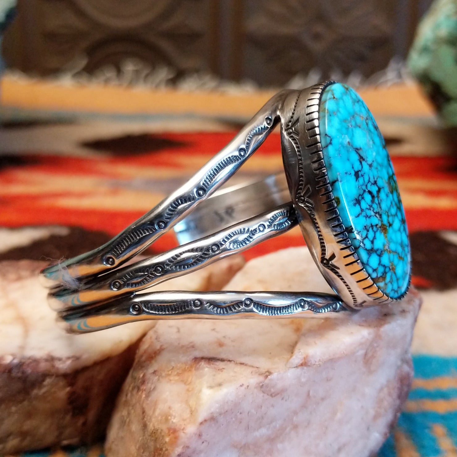 Sterling silver cuff bracelet with Kingman turquoise set in a large, oval bezel, featuring the tri-band with stamped designs.