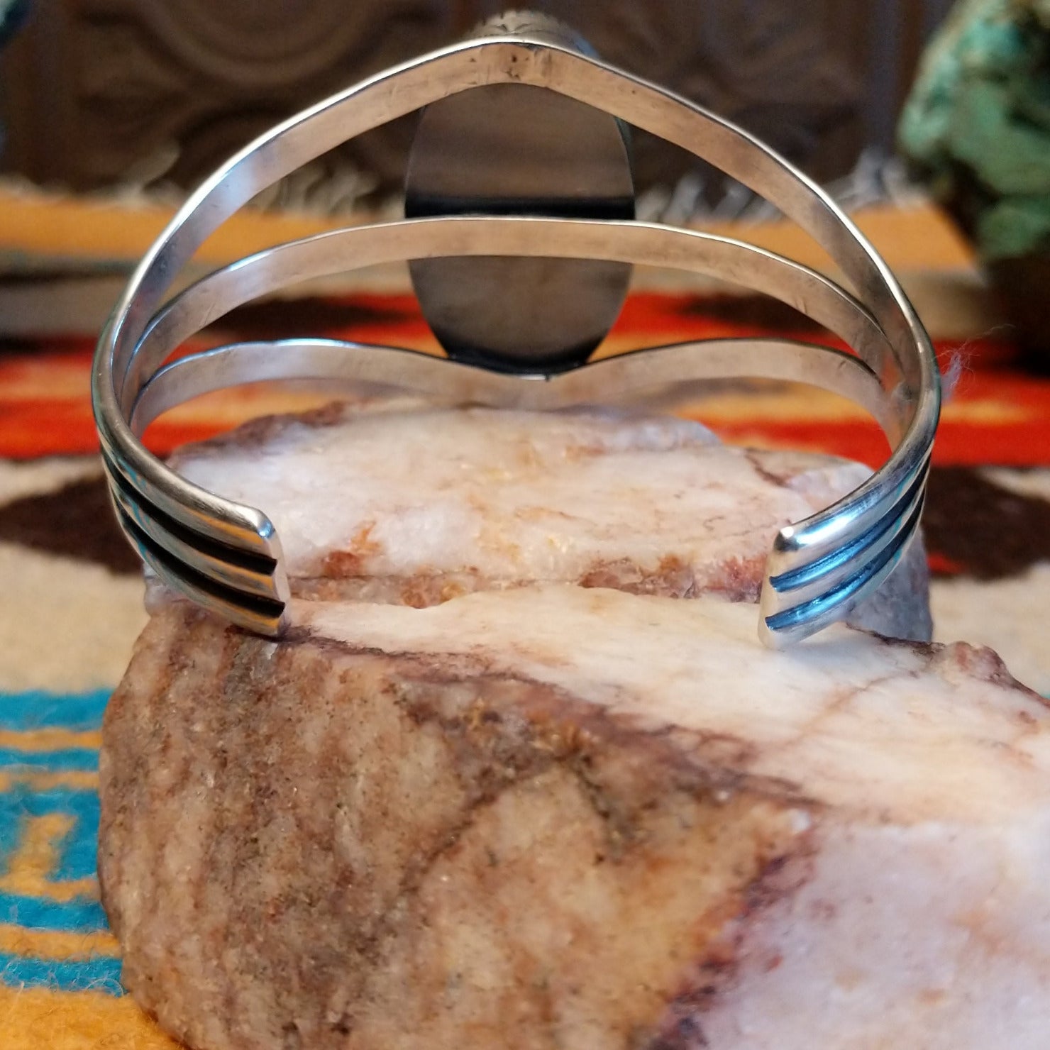 Sterling silver cuff bracelet with Kingman turquoise set in a large, oval bezel, featuring the tri-band with stamped designs.