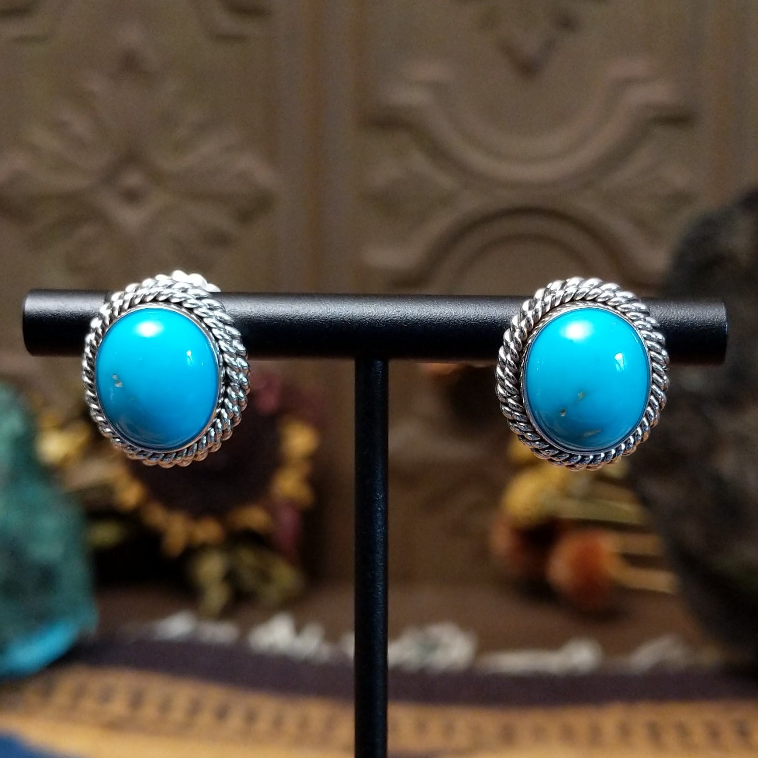 Sterling silver Kingman Turquoise stud earrings featuring oval blue stones with twisted rope borders.