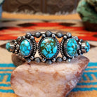 Sterling silver pentad cuff with Kingman turquoise set in round bezels, framed by twisted rope, star, and dotted accents.