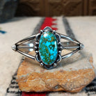 Kingman turquoise cuff by Murphy Platero featuring a large oval blue and green matrix stone framed by decorative silver beads, stamped accents, and an open split-band design.