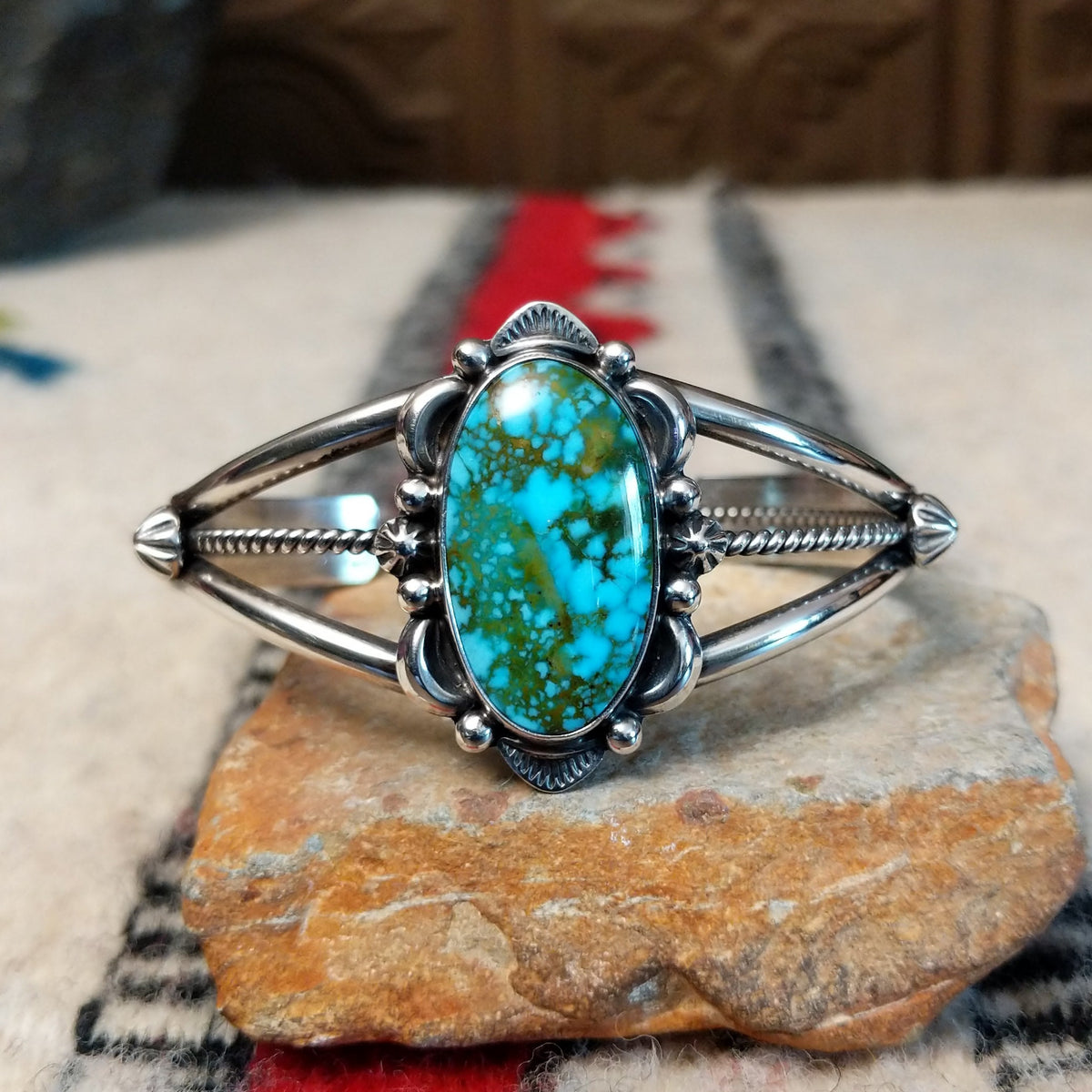 Kingman turquoise cuff by Murphy Platero featuring a large oval blue and green matrix stone framed by decorative silver beads, stamped accents, and an open split-band design.