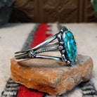 Kingman turquoise cuff by Murphy Platero featuring a large oval blue and green matrix stone framed by decorative silver beads, stamped accents, and an open split-band design; side view.