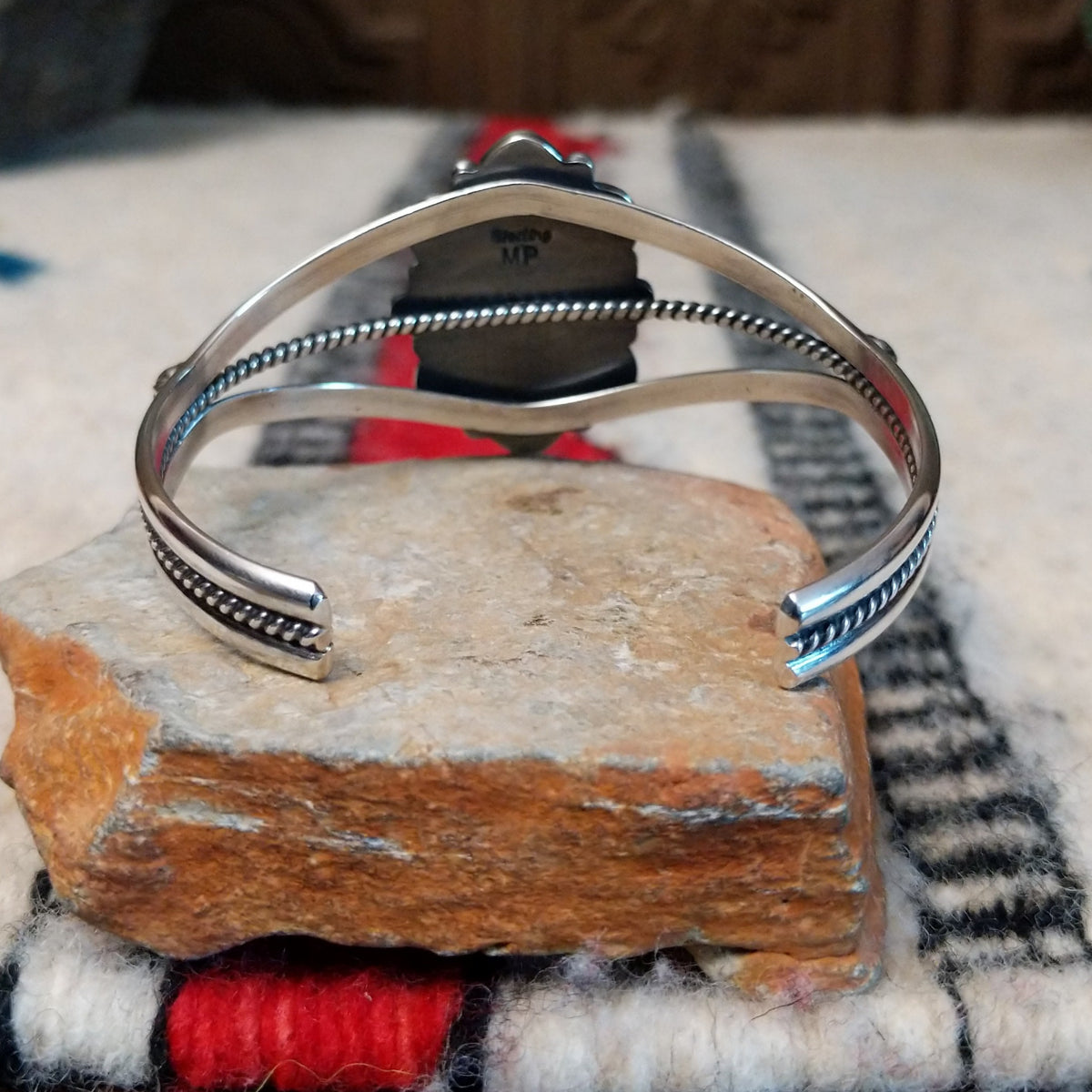 Kingman turquoise cuff by Murphy Platero featuring a large oval blue and green matrix stone framed by decorative silver beads, stamped accents, and an open split-band design; underside view.