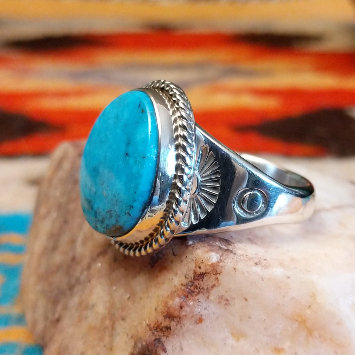 Sterling silver ring with Kingman turquoise set in the round bezel, framed by twisted rope detailing.