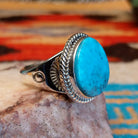 Sterling silver ring with Kingman turquoise set in the round bezel, framed by twisted rope detailing.