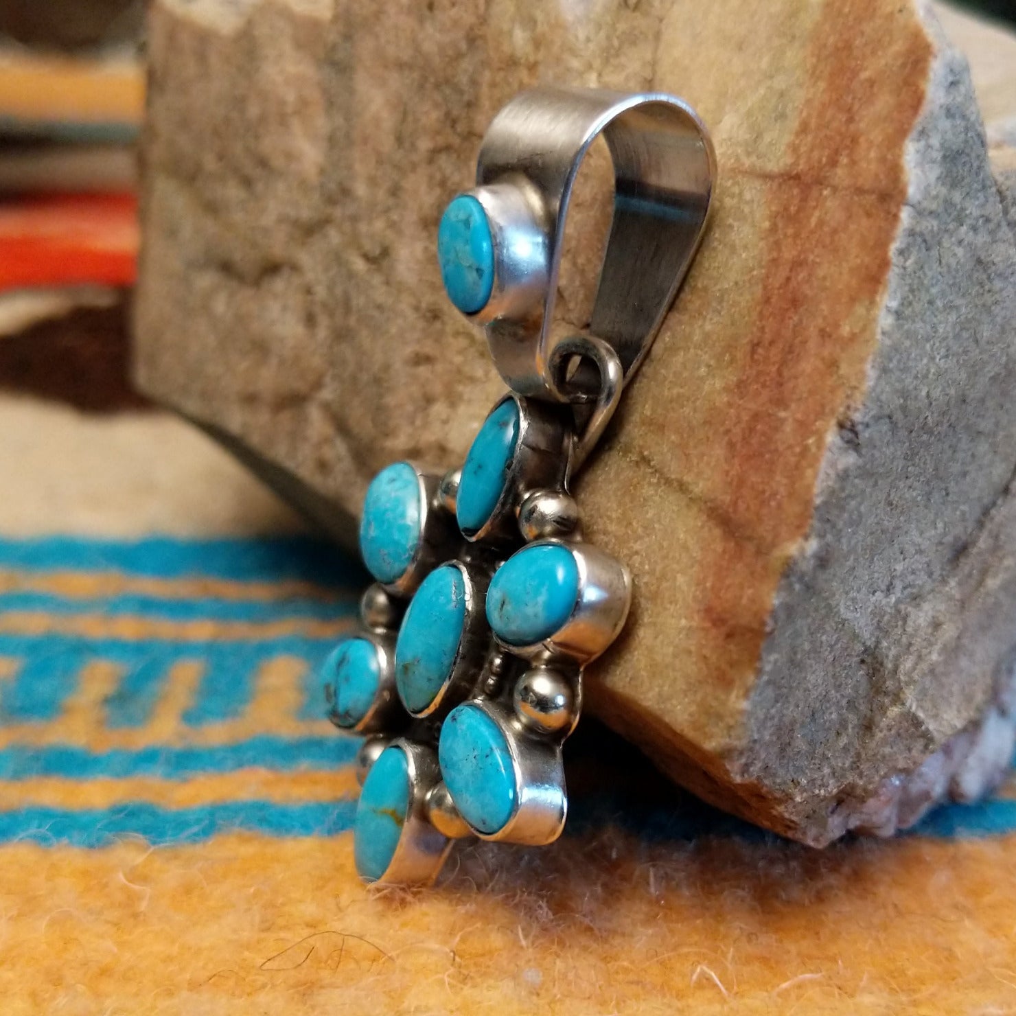 Sterling silver pendant with Kingman turquoise set in oval bezels that create a starburst design.