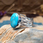 Sterling silver ring with Kingman turquoise set in a round bezel and strands of silver making up the band.