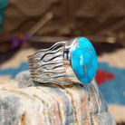 Sterling silver ring with Kingman turquoise set in a round bezel and strands of silver making up the band.