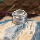 Sterling silver ring with Kingman turquoise set in a round bezel and strands of silver making up the band.