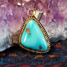 Kingman turquoise triangular gold pendant with a gold coil bezel.