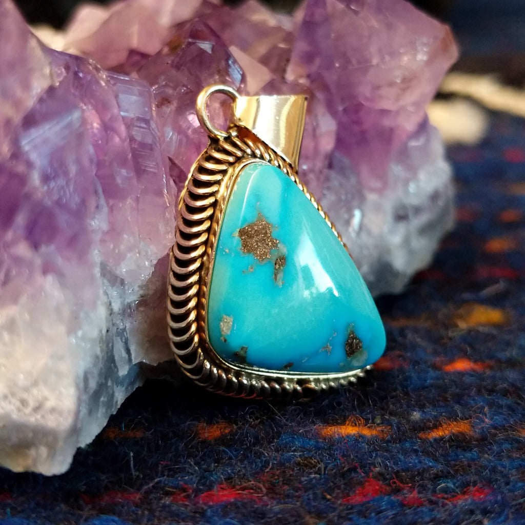 Kingman turquoise triangular gold pendant with a gold coil bezel.