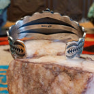 This sterling silver cuff bracelet features Kingman turquoise set in square bezels, framed by twisted rope and unique silverwork accents.