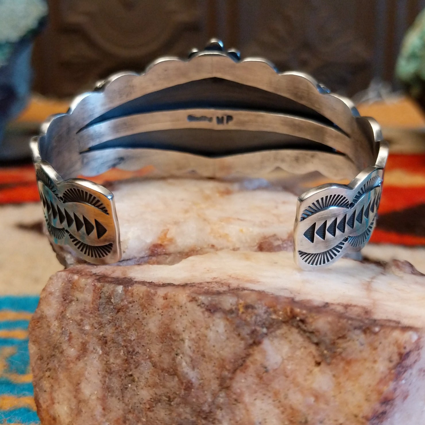 This sterling silver cuff bracelet features Kingman turquoise set in square bezels, framed by twisted rope and unique silverwork accents.